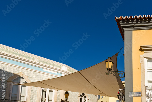 Canvases stretched for sun protection in the alleys of the old town of Faro, Algarve, Portugal
