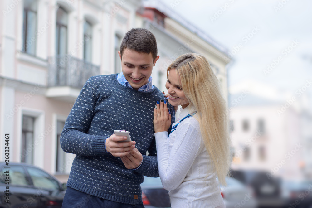 girl blond and guy looking something in the mobile phone and smi girl blond and guy looking something in the mobile phone and smi
