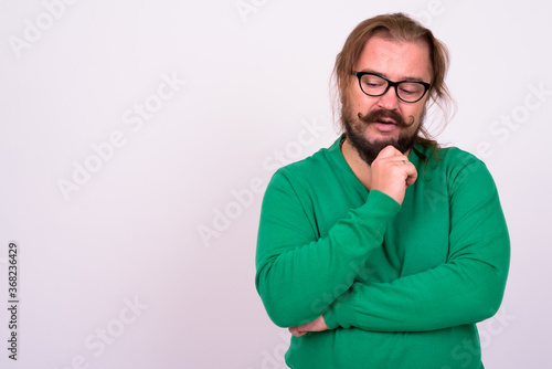 Bearded man with mustache and long hair against white background © Ranta Images
