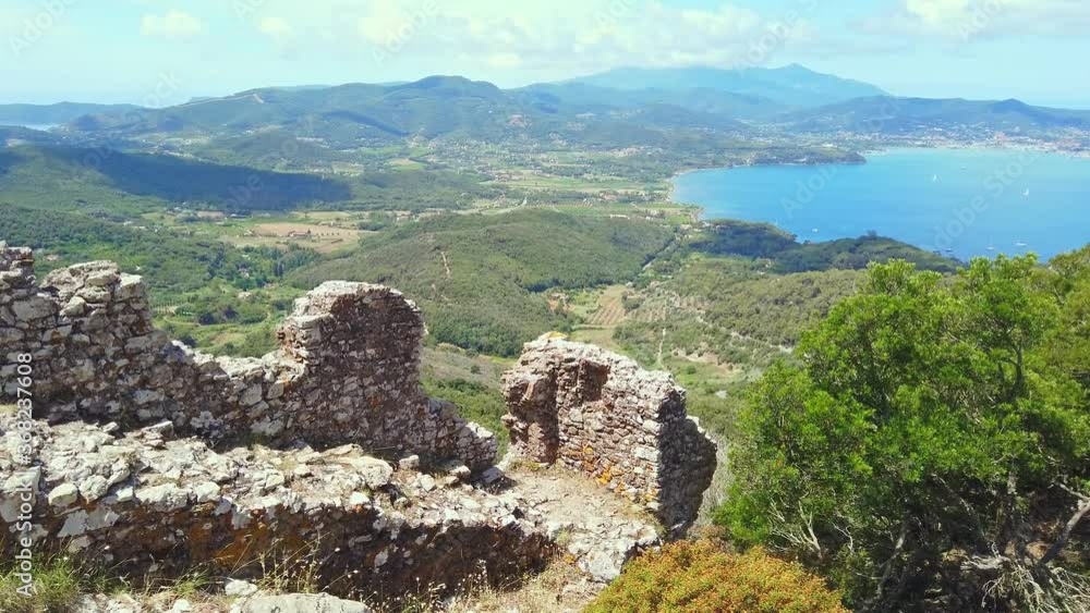 Ruin of the external walls around Volterraio Castle, oldest fortification on Elba Island, Tuscany, Italy, overlooking the gulf of Portoferraio. Panoramic views of Elba and Portoferraio city. Ruin of the external walls around Volterraio Castle, oldest fortification on Elba Island, Tuscany, Italy, overlooking the gulf of Portoferraio. Panoramic views of Elba and Portoferraio city.