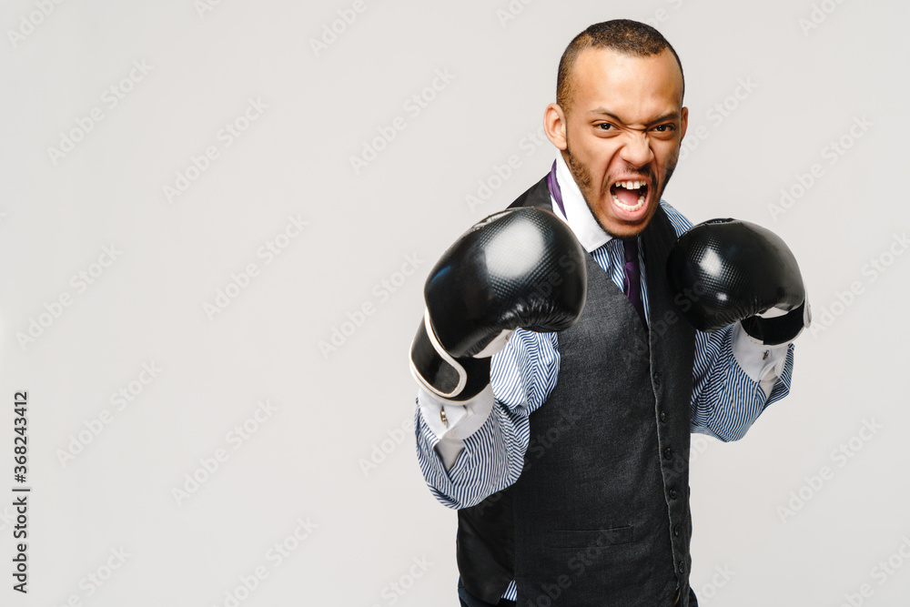 Angry upset young man office worker, business employee, fists in air with boxing gloves, open mouth yelling and shouting, negative emotion facial expression feeling Angry upset young man office worker, business employee, fists in air with boxing gloves, open mouth yelling and shouting, negative emotion facial expression feeling