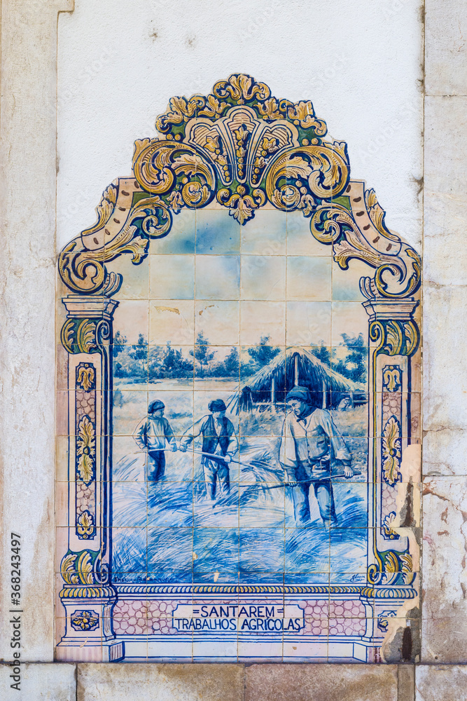 Portuguese Azulejos depicting typical regional scenes and monument on the facade of Santarem station , Portugal.