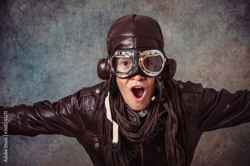 boy playing to be older in aviator suit on smooth background