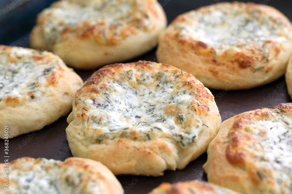 Open buns with cheese and herbs freshly baked from oven.