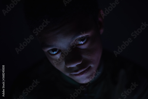 Close up portrait of teenager in dark room © rushay