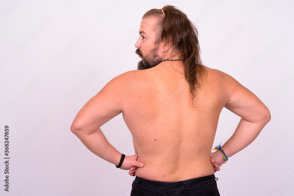 Bearded man with mustache and long hair shirtless against white background