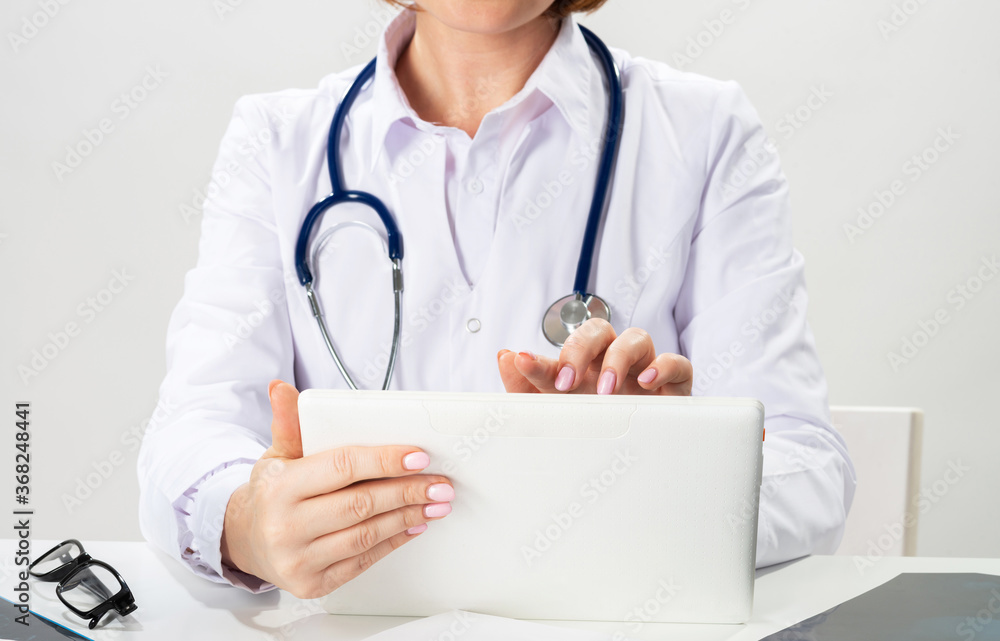 Close up female doctor hands using tablet computer Close up female doctor hands using tablet computer