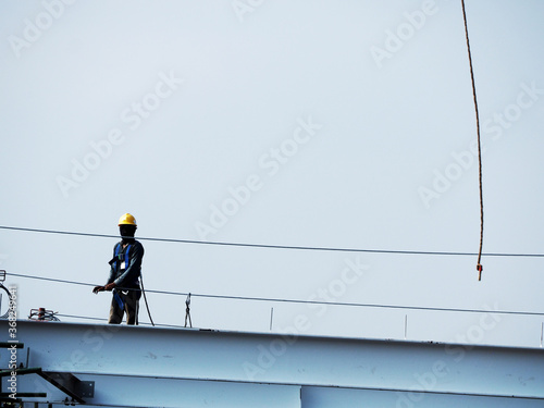 Man Working on the Working at height on construction site with blue sky