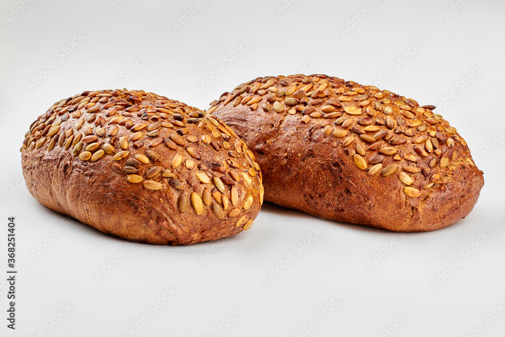 Organic wholmeal bread on white background. Two loaves of artisan bread with pumkin seeds. Healthy bread recipe.