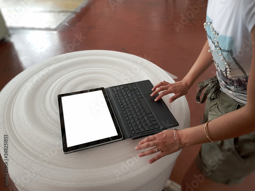 Donna con tablet pc su bobina in stabilimento industriale