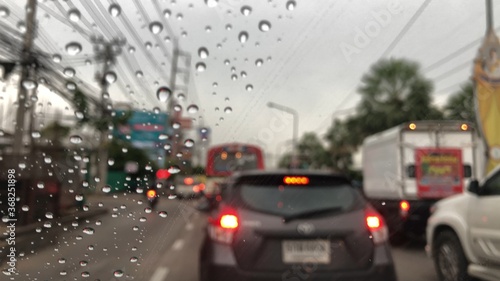 Colorful bokeh with street light at night rainy day,blurred view,drive car on the road in the lot rain.