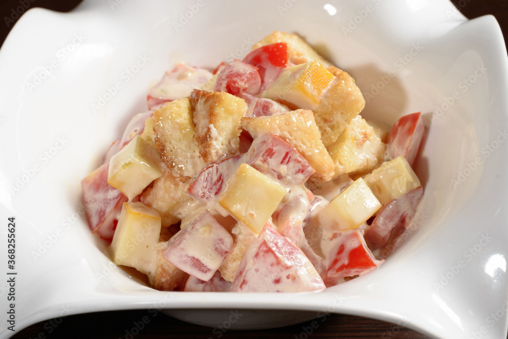 Salad served in the restaurant tomatoes fried bread and cheese seasoned with mayonnaise, close up. Photos for restaurant and cafe menus Salad served in the restaurant tomatoes fried bread and cheese seasoned with mayonnaise, close up. Photos for restaurant and cafe menus