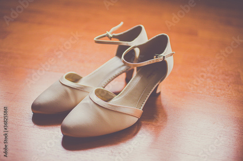 wedding shoes of the bride on a wooden floor in sepia