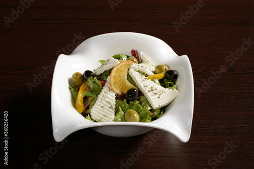 Delicious and healthy salad with vegetables and cheese seasoned with olive oil. Photos for restaurant and cafe menus