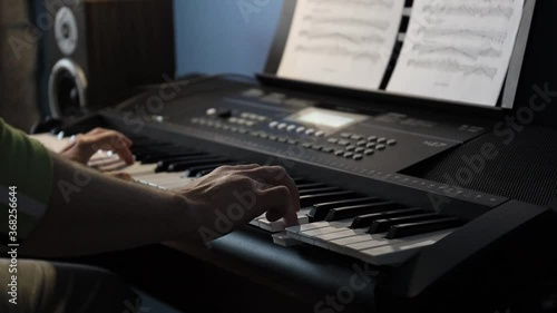 hands of a pianist playing a song in the studio on a synthesizer