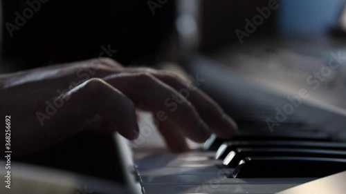 close-up of the hands of a pianist playing a song in the studio on a synthesizer