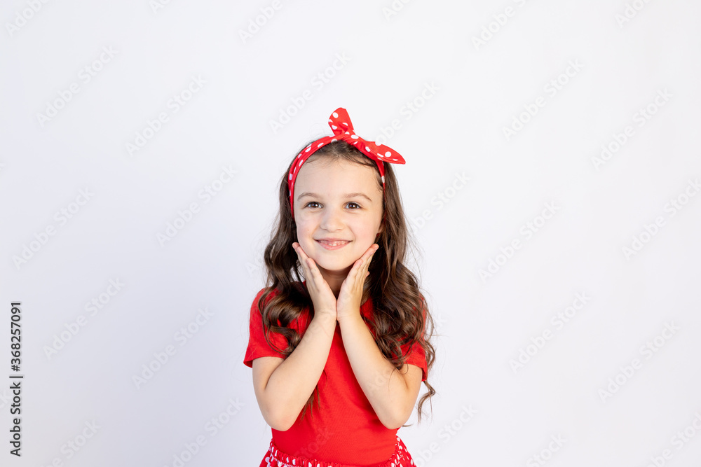 A cute little girl in a red dress on a white isolated background folded her hands on her cheeks. Space for text. Little girl celebrates birthday, holiday concept and sales A cute little girl in a red dress on a white isolated background folded her hands on her cheeks. Space for text. Little girl celebrates birthday, holiday concept and sales