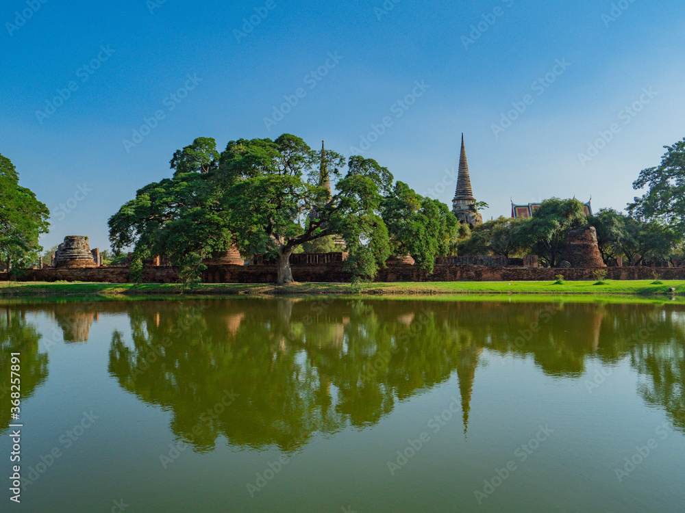 タイ、アユタヤ遺跡群のワット・プラシーサンペットと池の水面のリフレクションと緑の木々 / Wat Pra Srisanpet with reflection on pond and green trees at Ayutthaya, Thailand