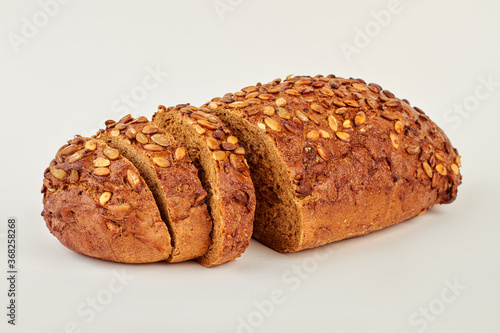 Fresh bread with seeds on white background. Dark grain bread with seeds.
