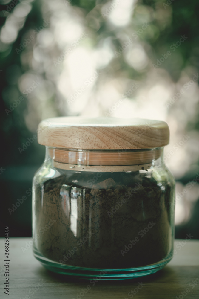 Dark cocoa powder in glass jar Dark cocoa powder in glass jar
