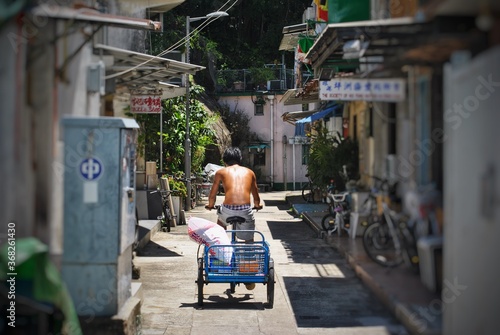 Photography Image of a man riding bicycle down an alley on the island of Peng Chau