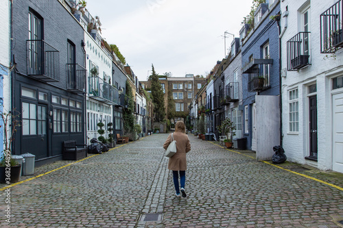 Obraz na płótnie Girl walking in a residential street in London, UK. Block of London houses. English architecture. Elegant apartment buildings. Real estate concept urban scene.European style of living w salonie