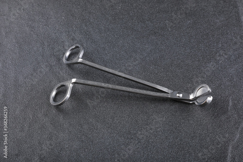 Obraz na plátně a silver aluminium wick trimmer for candle is put on the grey stone floor