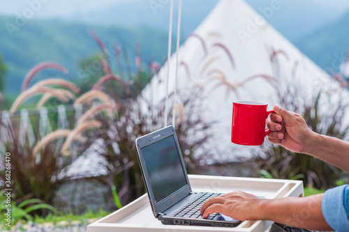 Businessmen use laptop computers to work online and drink coffee in tent, a mountain residence. photo