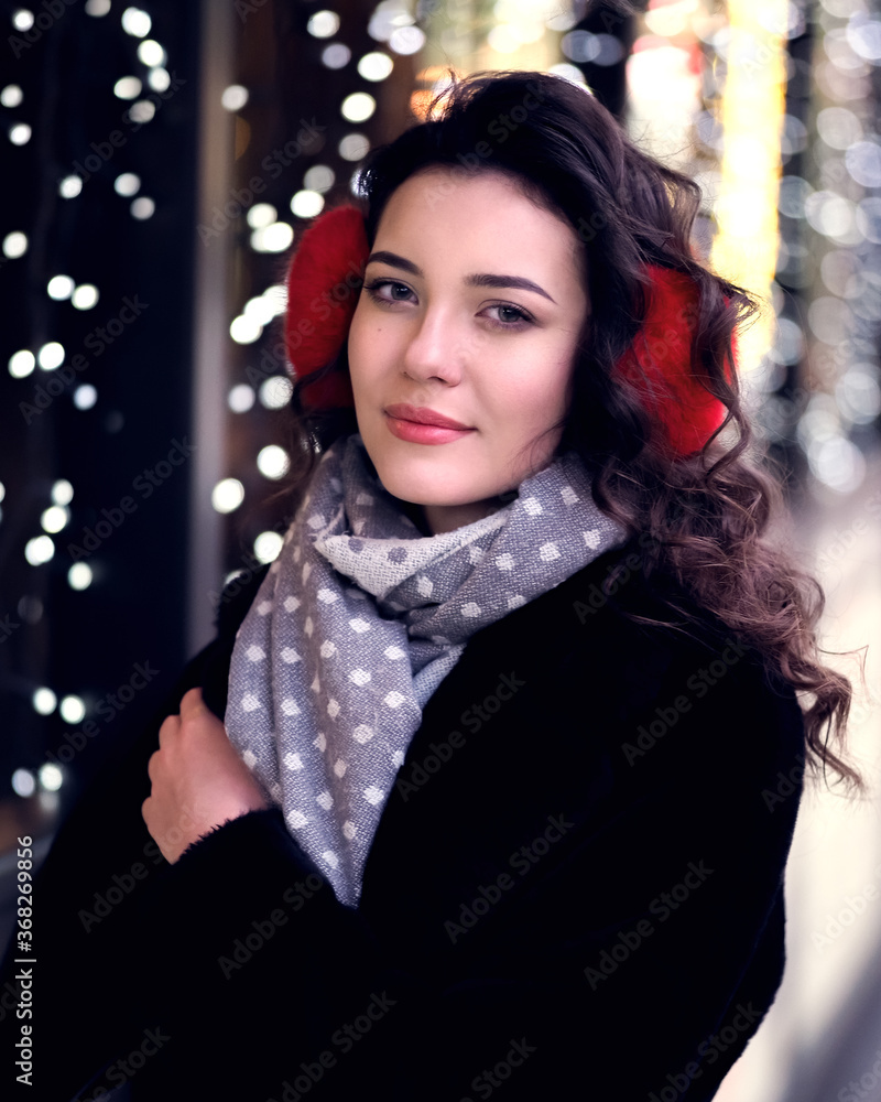 Brunette model posing near lights at the evening at the city