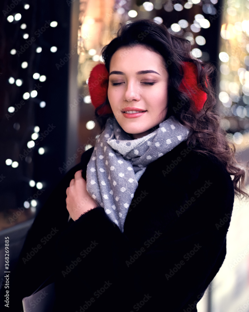 Brunette model posing near lights at the evening at the city