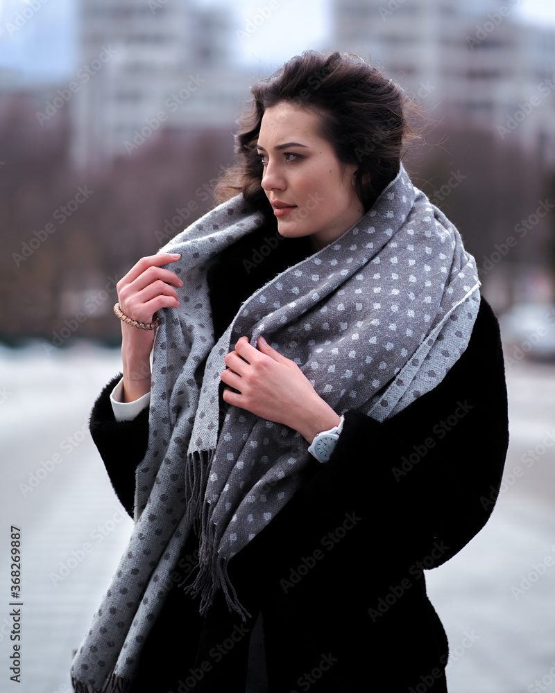 Brunette model with curly hait posing at the city streets