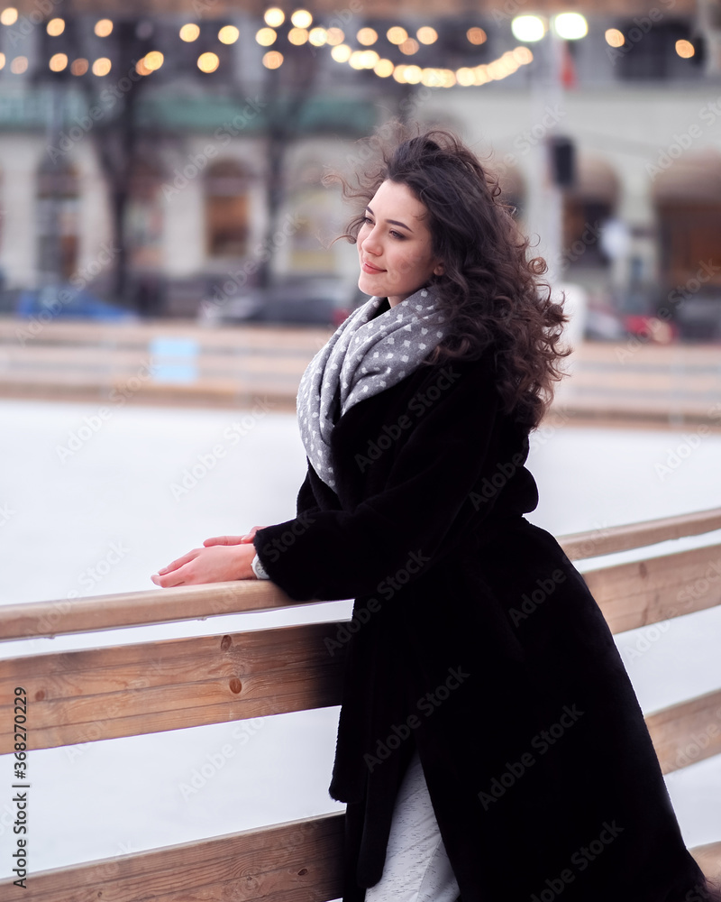 Brunette model makes fun near the city ice rink in the winter