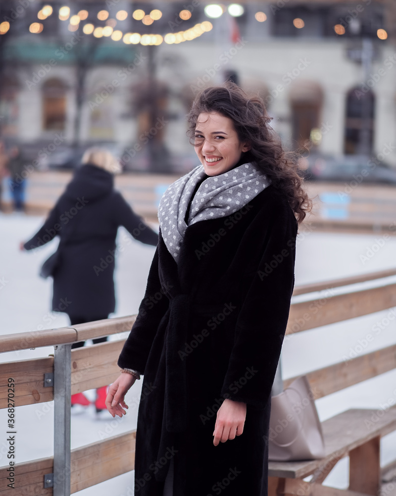 Brunette model makes fun near the city ice rink in the winter