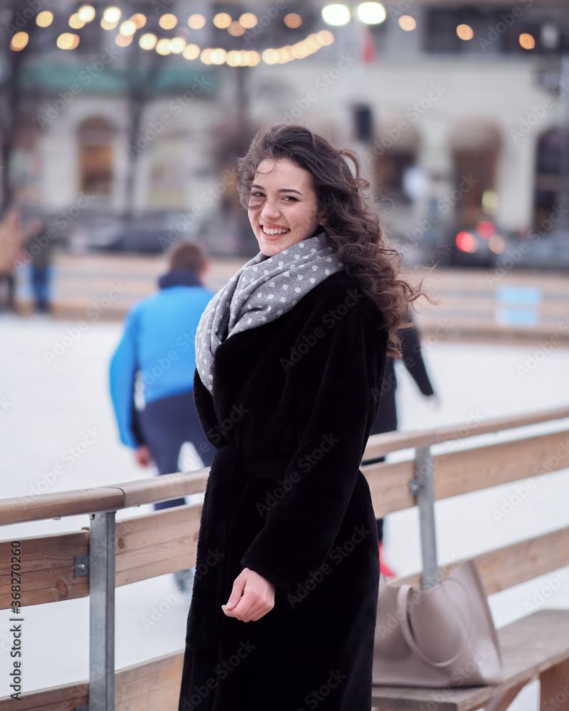 Brunette model makes fun near the city ice rink in the winter