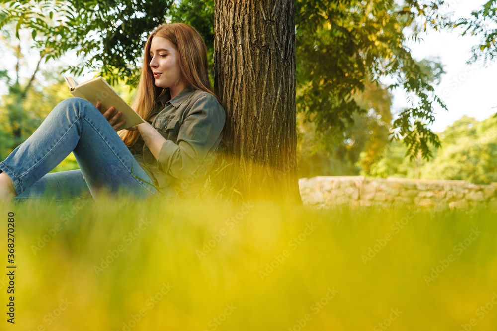 © Drobot Dean - Girl reading a book in park