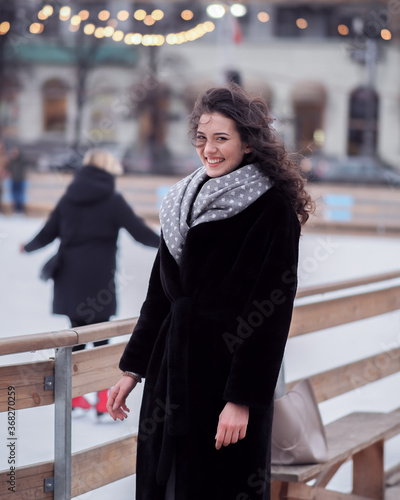 Brunette model makes fun near the city ice rink in the winter