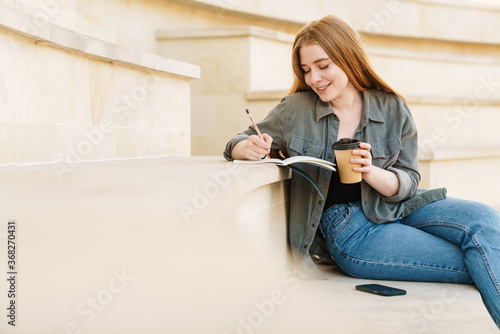 Attractive young girl writting in a notebook