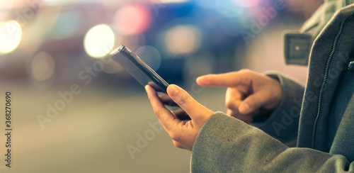 smartphone social media close up famale hand touch blank screen mock up device screen smartphone with blur bokeh cityscape building light flare effect business technology connection