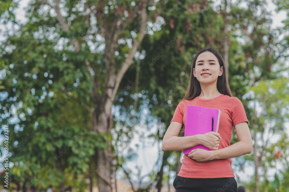 Young Asian Women holding book standing outdoor back to school,Concept back to school education study Young Asian Women holding book standing outdoor back to school,Concept back to school education study