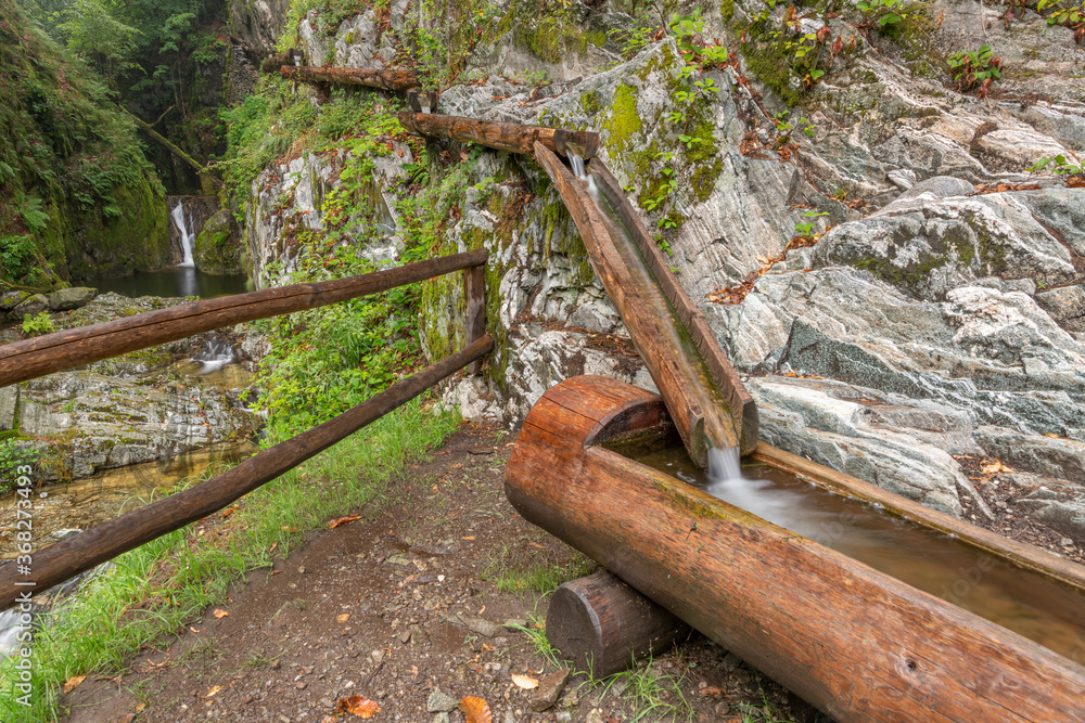 Wooden pipe. Aqueduct. Primitive water supply system from wooden gutters. Wooden pipe. Aqueduct. Primitive water supply system from wooden gutters.