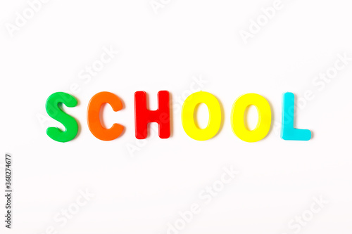 the word school from multi-colored letters on a white background. Concept back to school. Study concept. flat lay, top view, minimalism.
