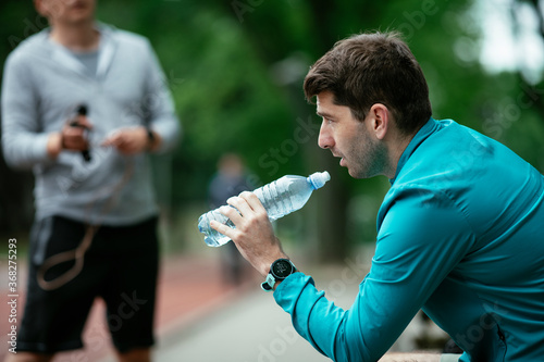 Thirsty athlete. Man having water after a workout..