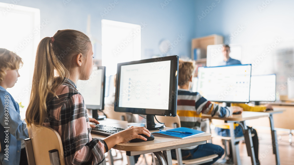 Elementary School Computer Science Classroom: Cute Little Girl Uses Personal Computer, Learning Programming Language for Software Coding. Schoolchildren Getting Modern Education. Elementary School Computer Science Classroom: Cute Little Girl Uses Personal Computer, Learning Programming Language for Software Coding. Schoolchildren Getting Modern Education.