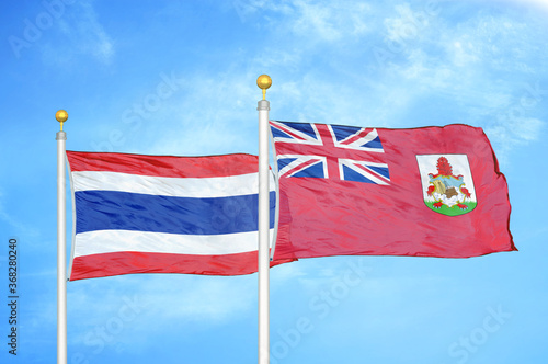 Thailand and Bermuda two flags on flagpoles and blue sky photo