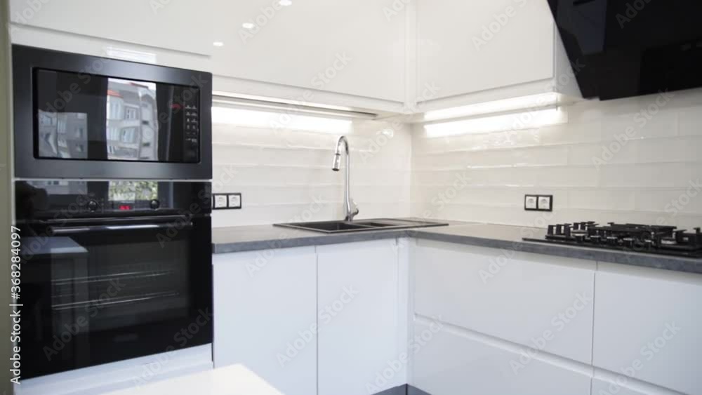 White compact kitchen interior with built-in household appliances White compact kitchen interior with built-in household appliances