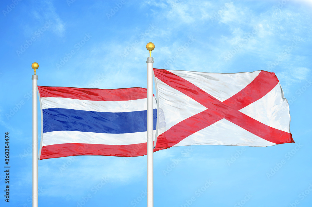 Thailand and Northern Ireland two flags on flagpoles and blue sky