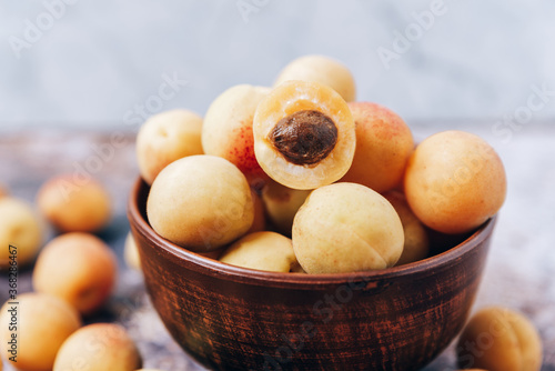 Lots of ripe yellow apricots close up in a crockery on the table