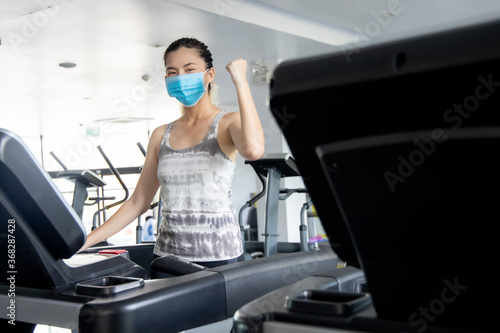 Women wearing masks exercise in the gym to keep social distance.