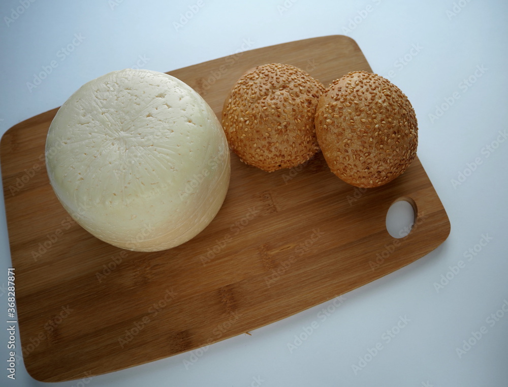 Head of cheese with a loaf of bread, baguette, buns with poppy seeds, close-up, wooden Board Head of cheese with a loaf of bread, baguette, buns with poppy seeds, close-up, wooden Board