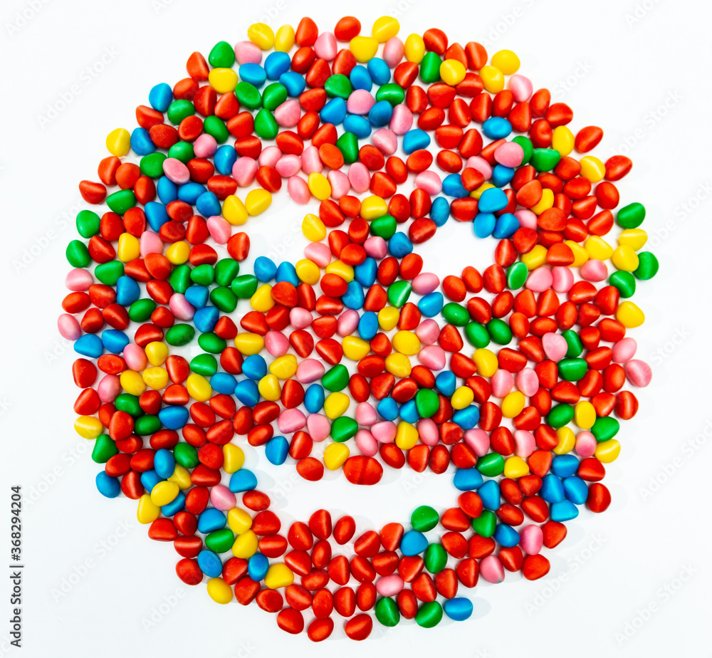 jelly beans forming a drawing of a face of various colors with a white background